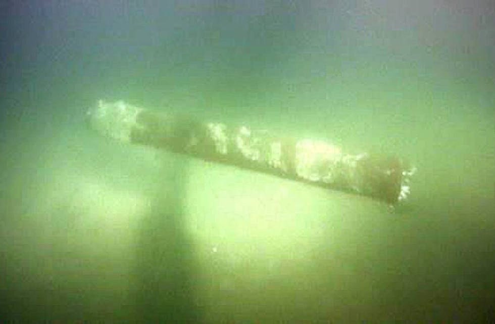Denne 4 meter lange torpedoen ble funnet oppå NordNed kabelen som går mellom Flekkefjord og Nederland. Det skjedde i 2014, da Russland annekterte Krim. Kabelen ligger rett under og ses derfor ikke på bildet, ca. en halv meter under grunnen (nedgravd under torpedoen). Foto: Statnett